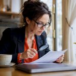 Translator reviewing academic document with magnifying glass