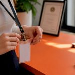 Hands adjusting translator ID badge